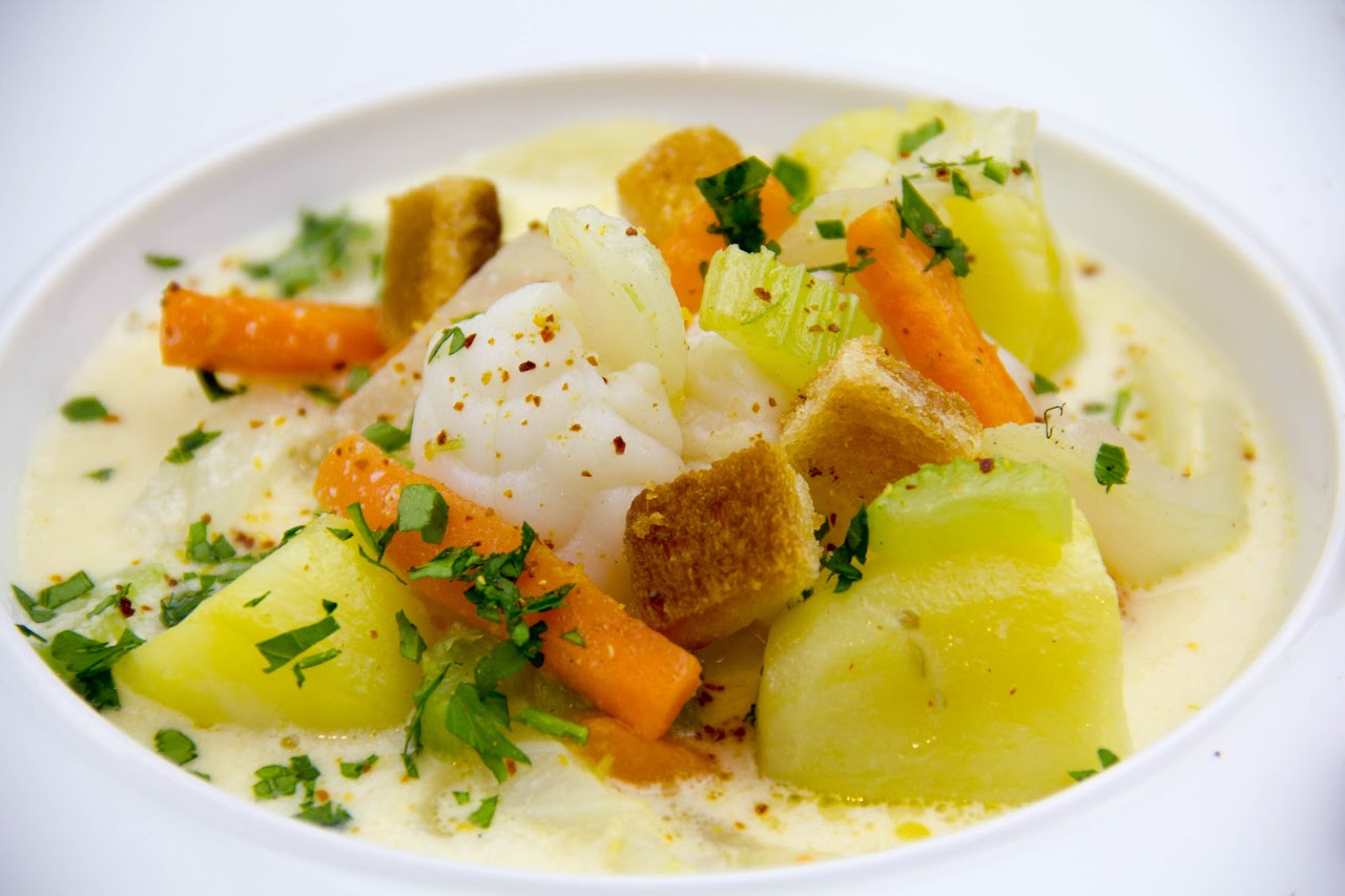 Assiette gastronomique dressée : poisson, légumes croquants et persillade.